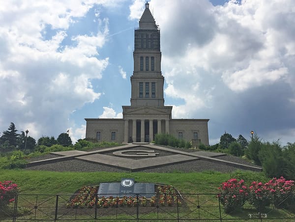 Exterior photo of the George Washington Masonic National Memorial sitting on a grassy hill.