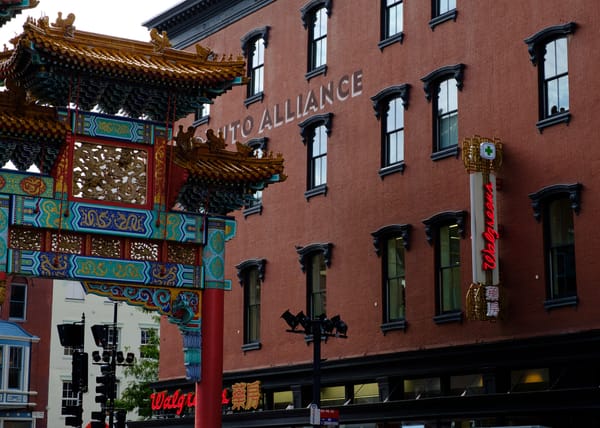 Chinatown arches slightly out of frame next to a red brick building. 
