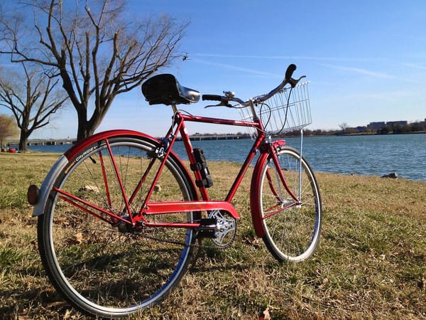 a red bike propped on a kick stand in from of the Potomac River 