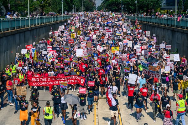 A crowd protesting Trump's takeover walking down 16th Street. 