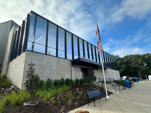 The outside of the Fort Dupont Ice Rink, which has large glass windows and an American flag out front.