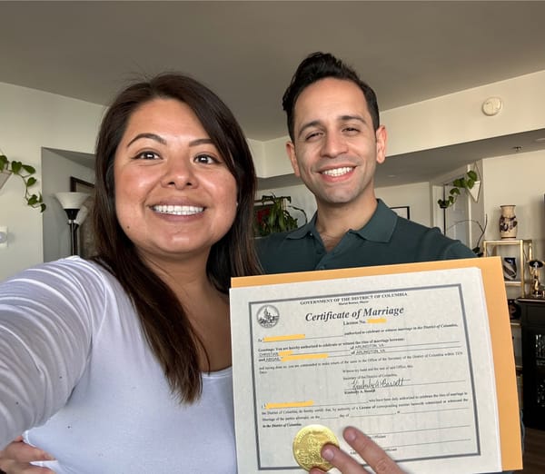Two people hold a marriage license issued by the District of Columbia. 