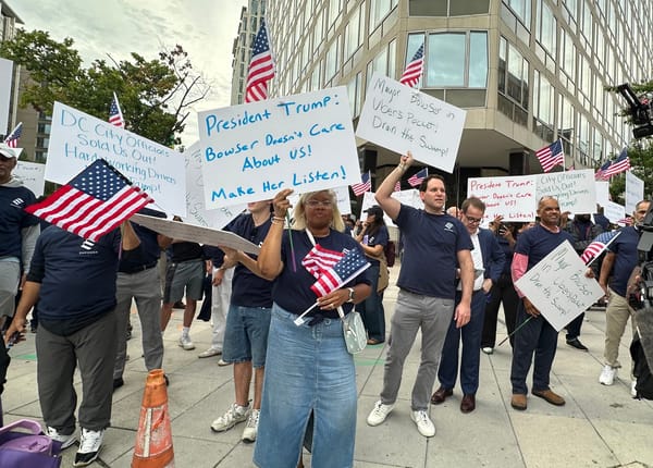A group of protests hold American flags and signs calling on President Trump to intervene. 